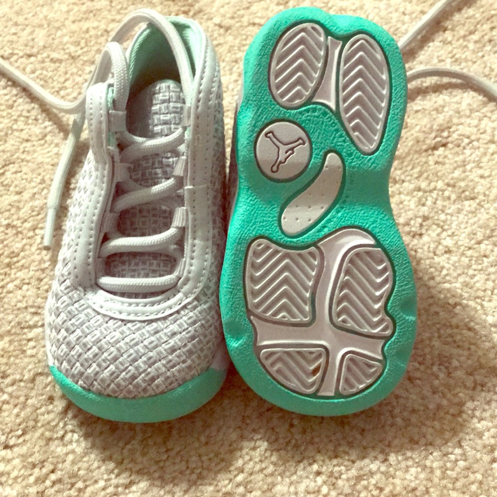 Grey tennis shoes with teal accent.